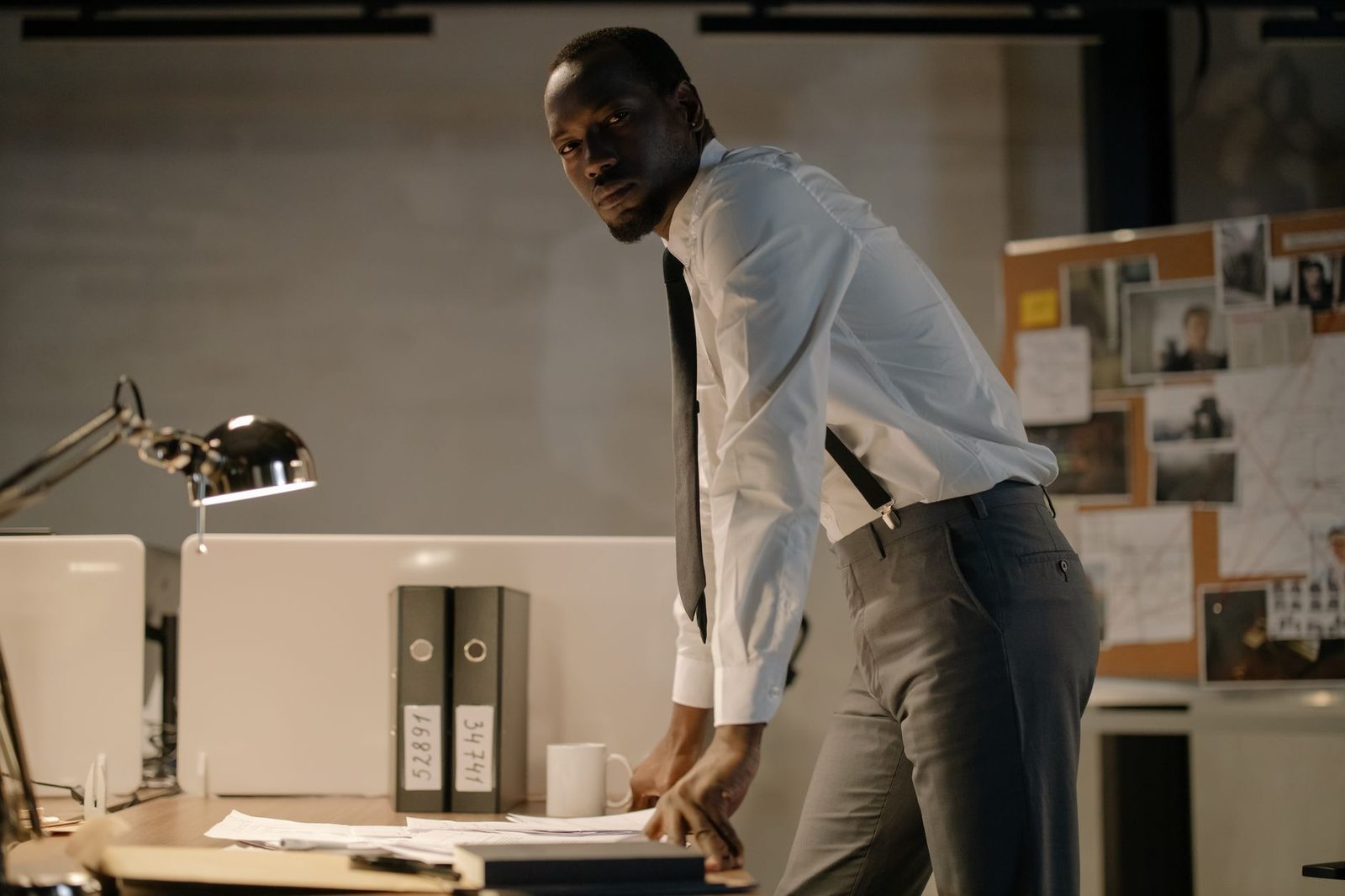 Detective reviewing case documents at office desk.
