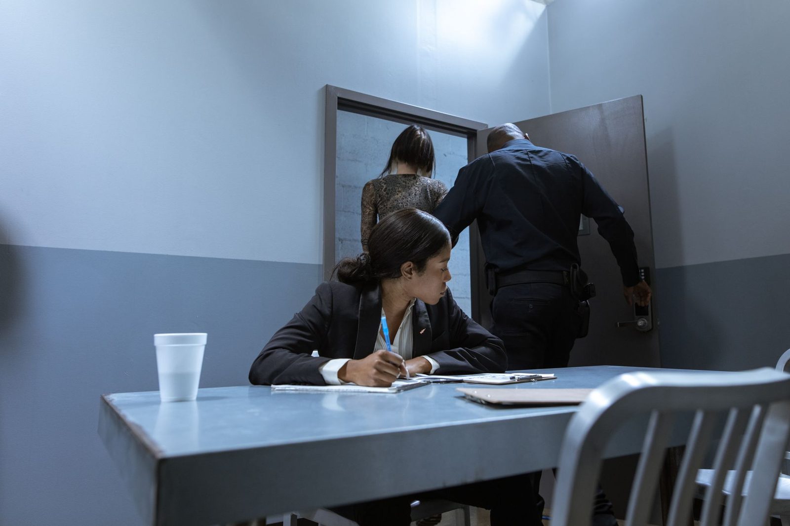 Police officer escorts a suspect while a