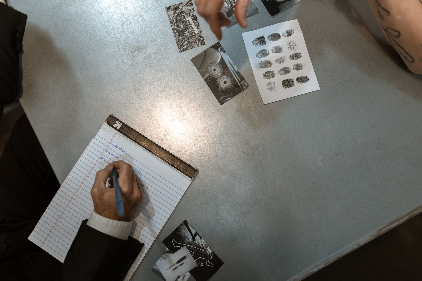 Two officers review case evidence and take notes during an investigation.